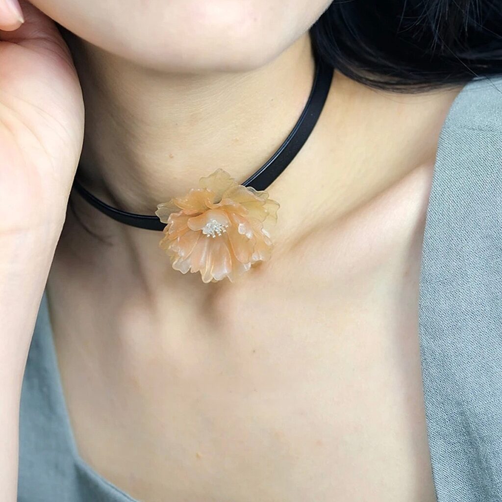 This is a choker necklace starring a temperature - reactive leather flower! Crafted with leather - working techniques, the flower boasts an awesome thermochromic trait — it subtly shifts colors with body heat or ambient temperature, coming alive with dynamic charm. Paired with a minimalist black choker band, it balances simplicity and thoughtful details perfectly. For daily wear, it’s an eye - catching neckline highlight, matching casual, light - retro styles, etc. The unique temperature - changing effect breaks the monotony of outfits, adding fun and personality. Ideal for those chasing novel aesthetics and wanting to showcase taste with one - of - a - kind accessories ！